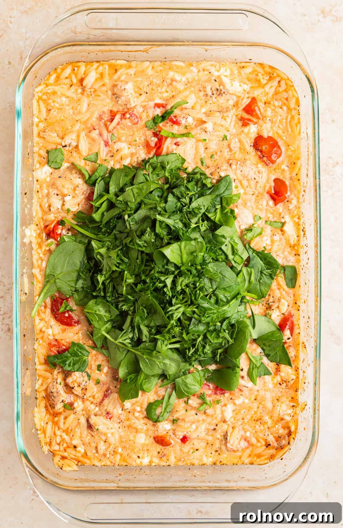 Aegean Chicken and Orzo Bake 9 Freshly chopped spinach and parsley generously sprinkled over the hot Greek chicken and orzo bake in the pan, ready to be stirred in and wilted by the residual heat.