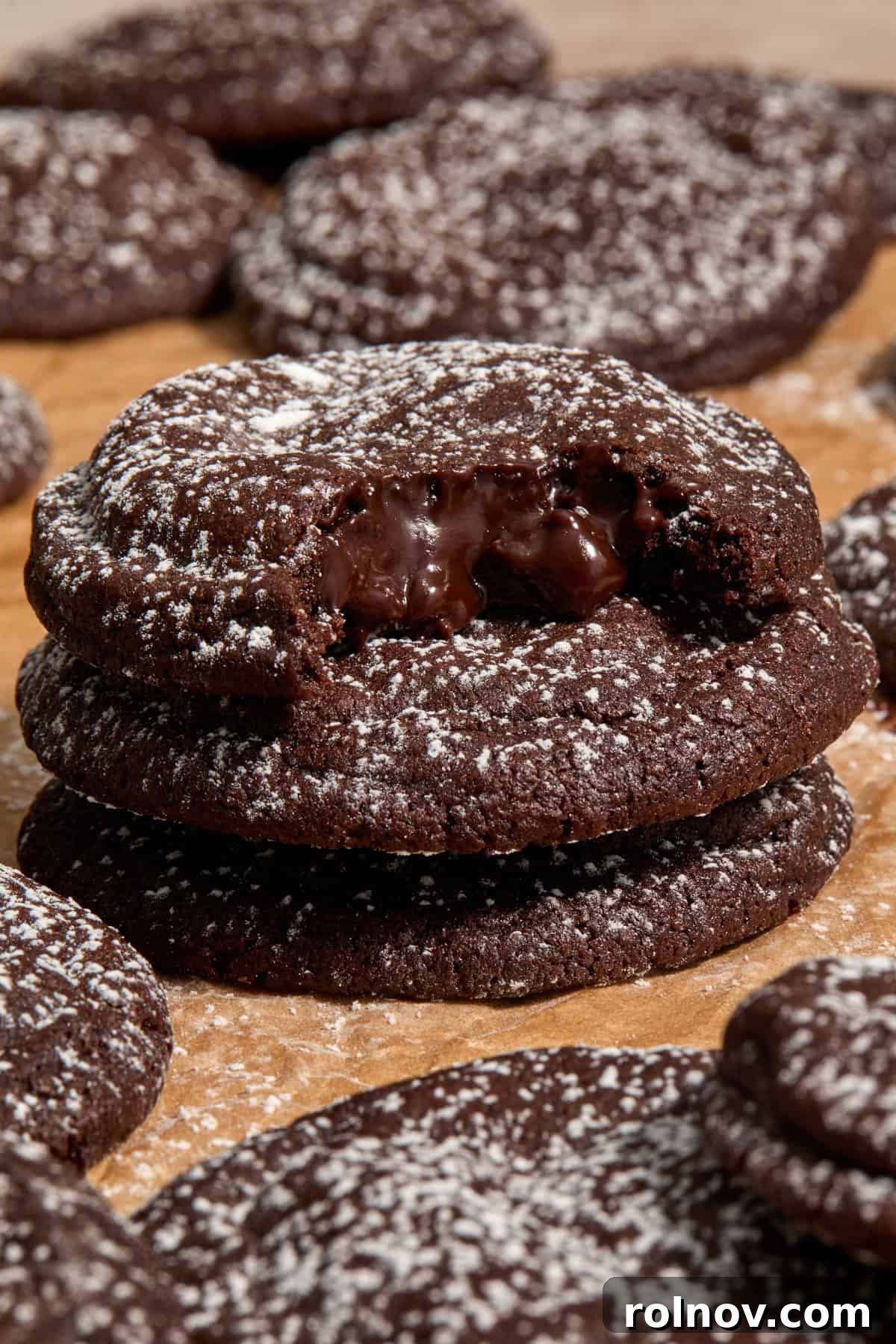 A stack of warm chocolate lava cookies dusted with powdered sugar.