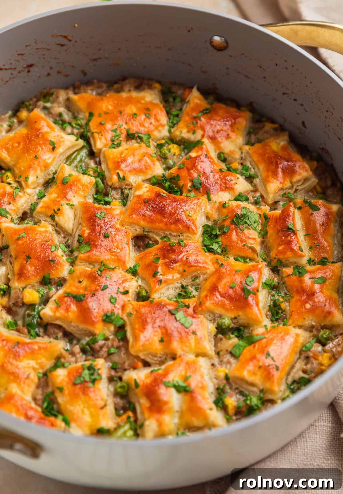 Comforting Ground Turkey Pot Pie 2 Golden-brown ground turkey pot pie in an oven-safe pan, topped with flaky puff pastry squares, ready to serve.