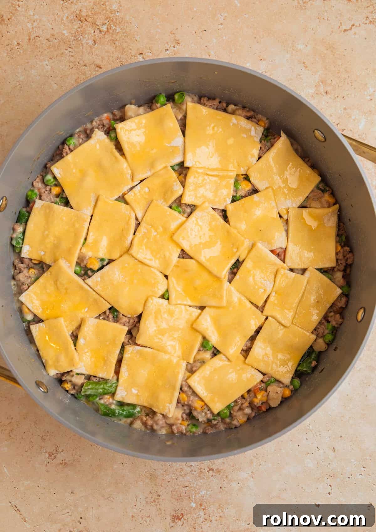 Comforting Ground Turkey Pot Pie 7 Cut squares of puff pastry neatly arranged over the ground turkey and vegetable filling in the pan, brushed with egg wash.