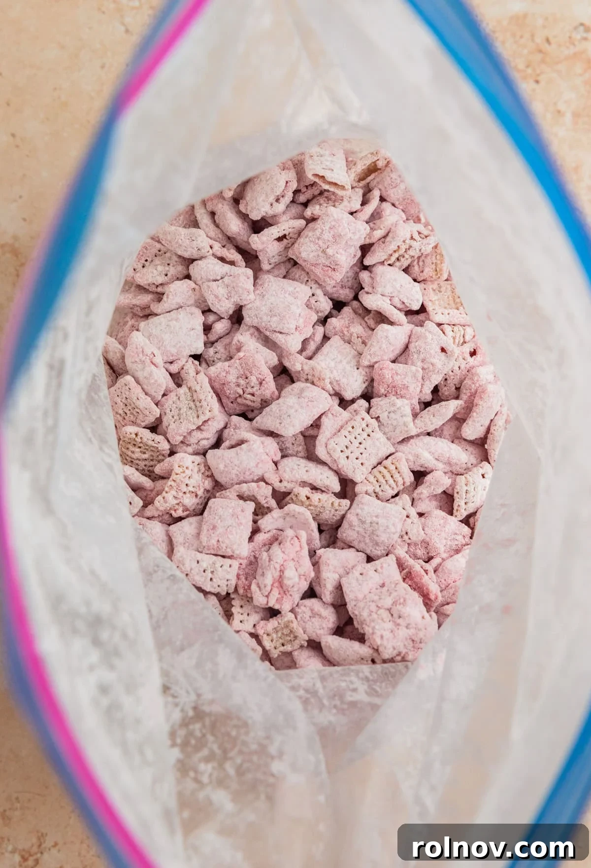 Sweet Strawberry Crunch 12 Fully coated strawberry puppy chow, covered in powdered sugar, inside the ziplock bag.