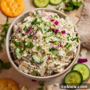 Bowl with feta chicken salad topped with fresh dill and parsley, ready to be served.