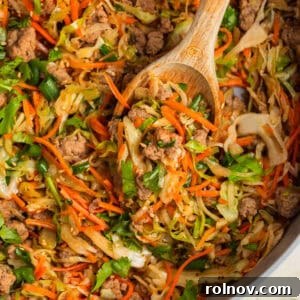 Pot with egg roll bowl made with ground turkey with wooden spoon propped in it.