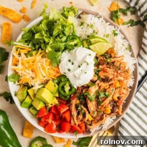 Slow cooker chicken burrito bowl with rice, beans, corn, cheese, lettuce and more.