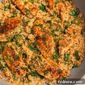 Herbed chicken and rice in pan topped with chopped parsley.