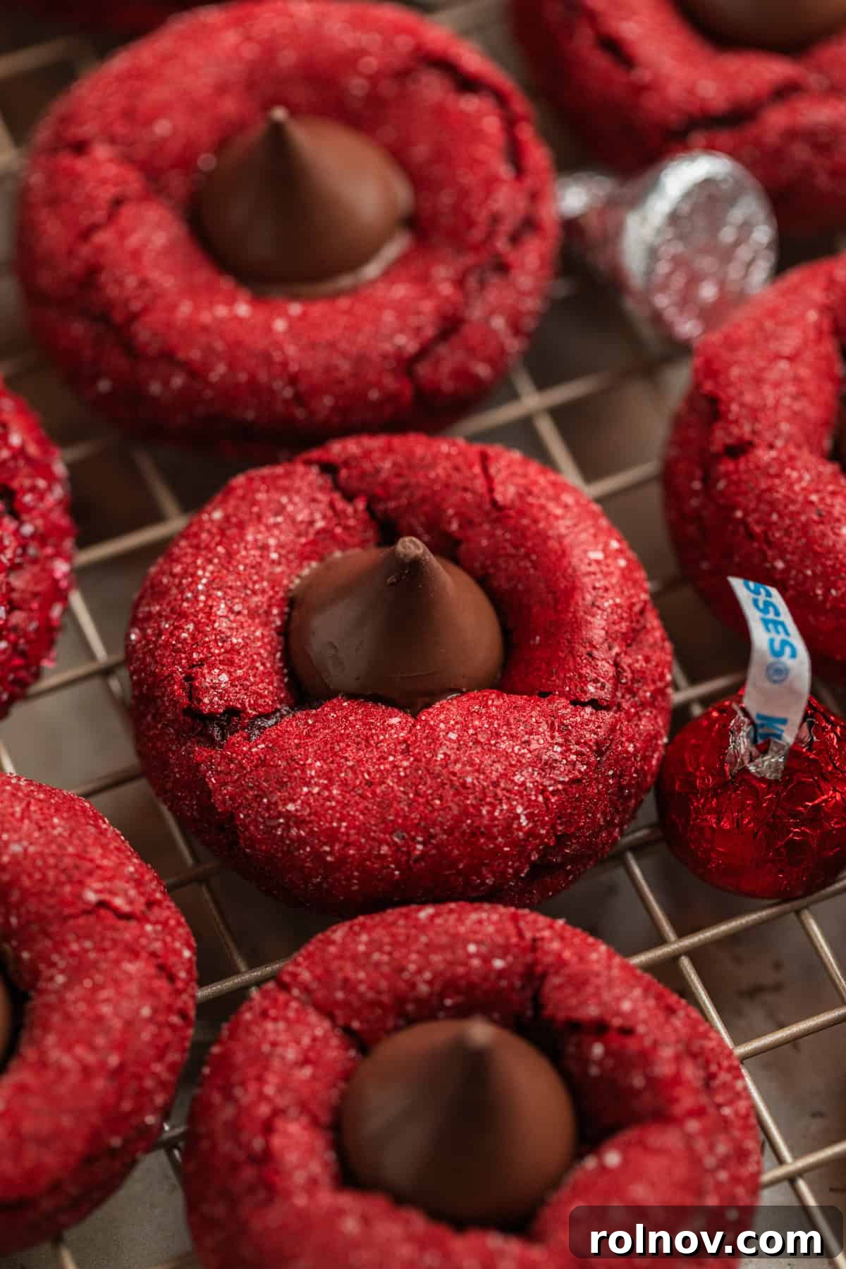 Freshly baked red velvet blossom cookies cooling on a wire rack.
