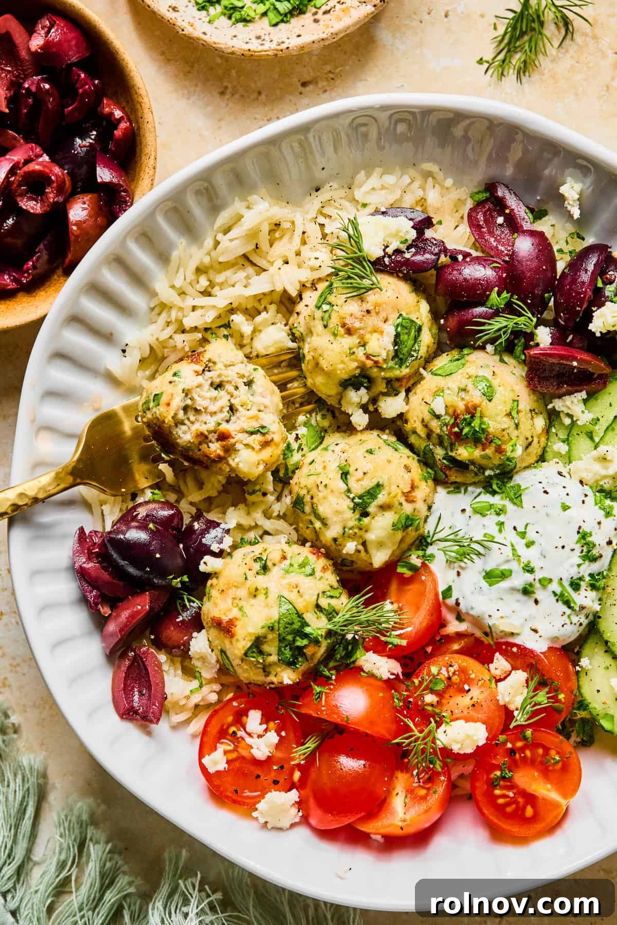 Turkey Meatballs with a Spinach-Feta Swirl 11 Fork in turkey feta meatball in rice bowl with dill yogurt sauce.