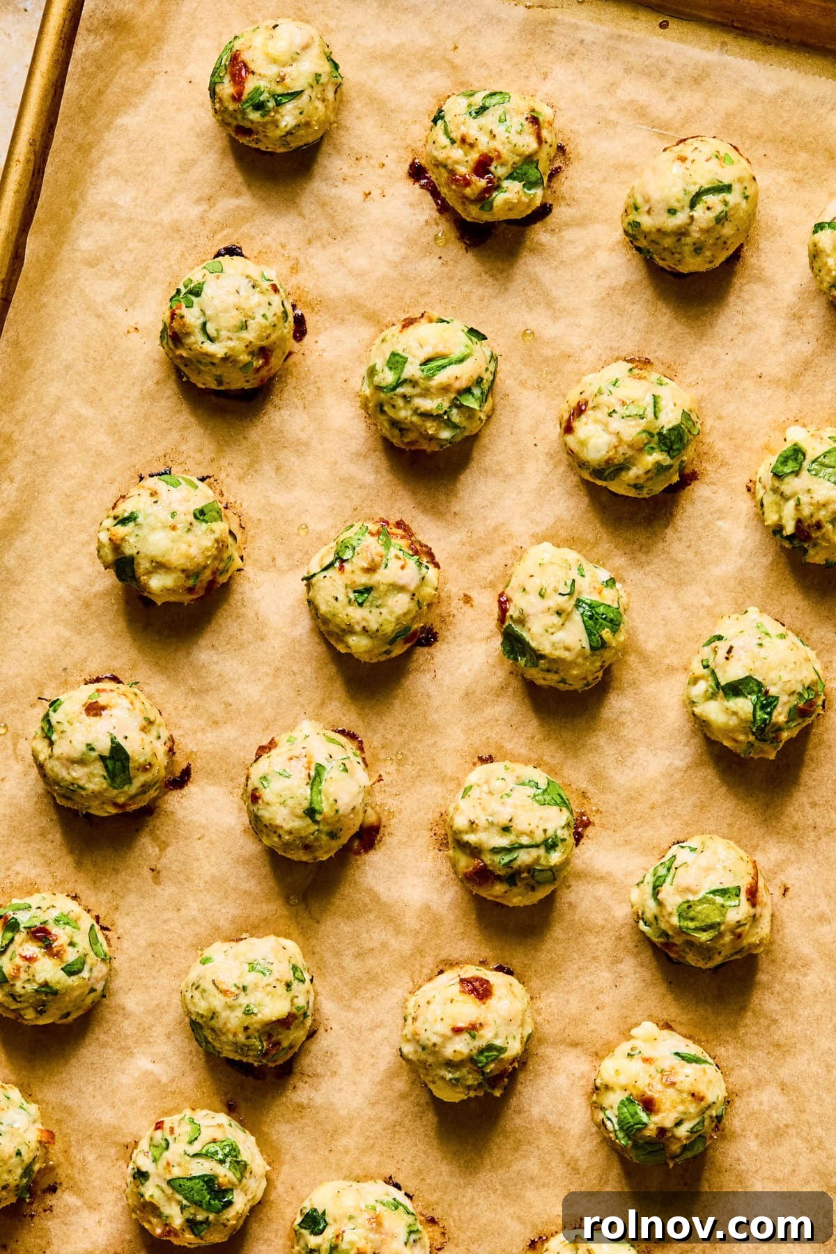 Turkey Meatballs with a Spinach-Feta Swirl 9 Baked meatballs on parchment lined cookie sheet.