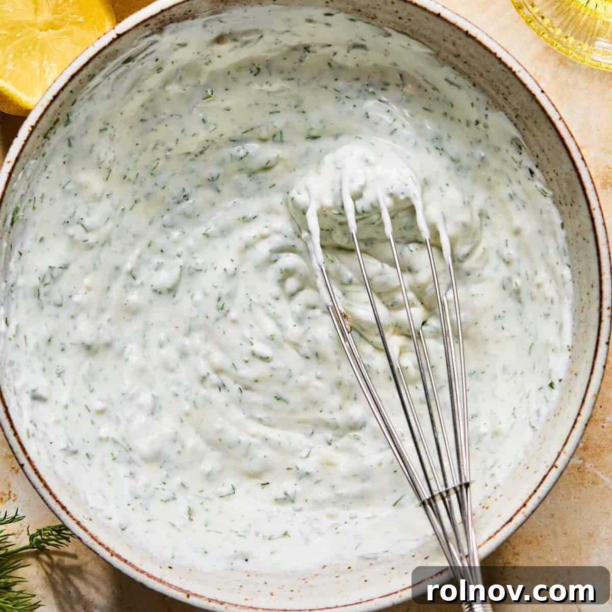 Turkey Meatballs with a Spinach-Feta Swirl 10 Mixed dill yogurt sauce in bowl with whisk.