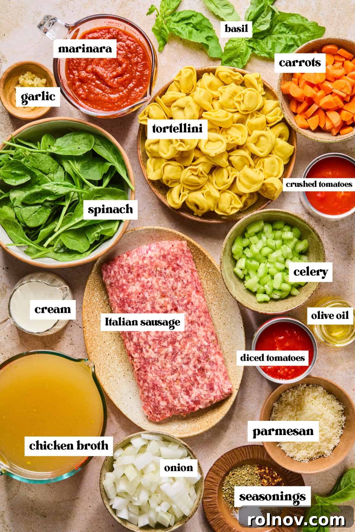 Slow Cooker Creamy Sausage Tortellini Soup 4 A vibrant display of fresh ingredients for the Crockpot Sausage Tortellini Soup, including chopped carrots and celery, fresh spinach, heavy cream, browned Italian sausage, various canned tomatoes, and essential seasonings.