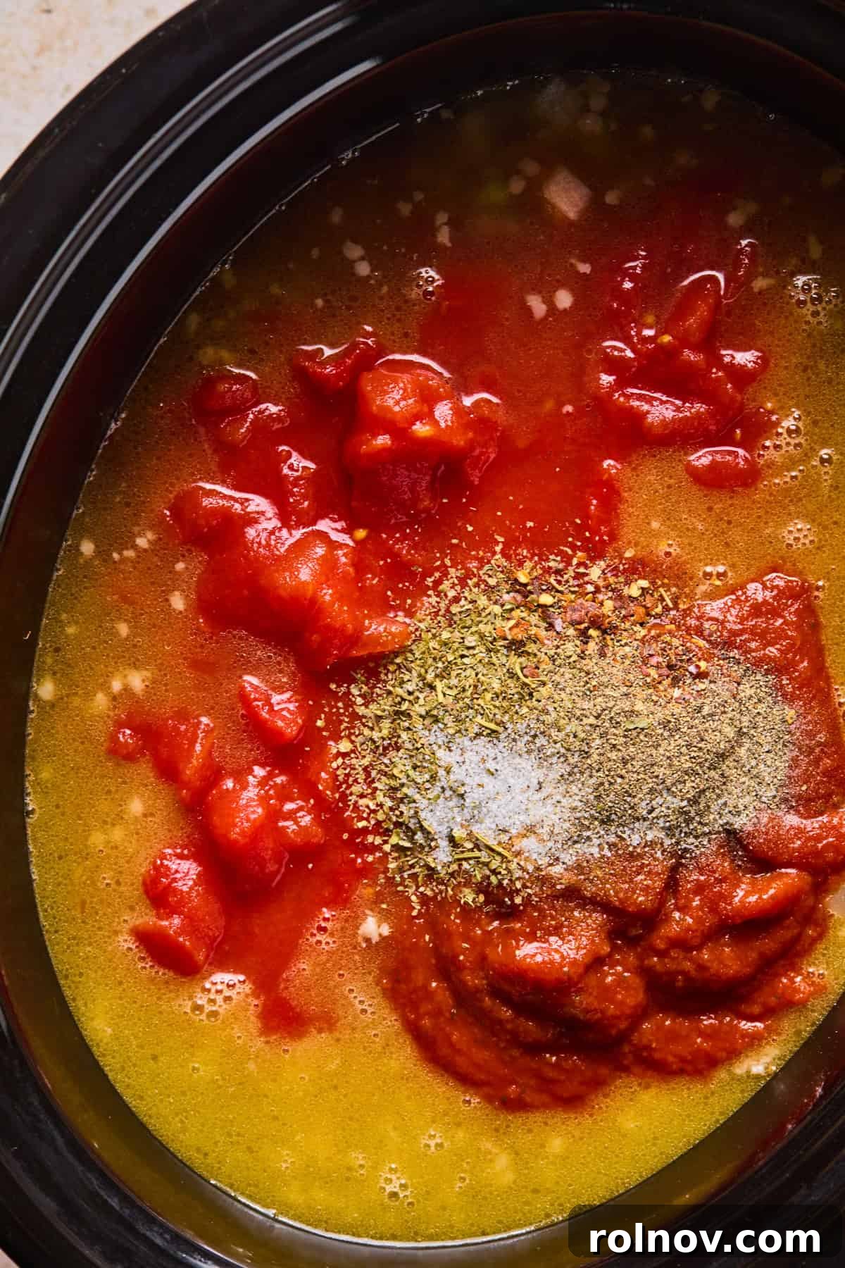 Slow Cooker Creamy Sausage Tortellini Soup 9 A mix of broth, marinara sauce, crushed and diced tomatoes, and Italian seasonings poured into the slow cooker over the meat and vegetables.