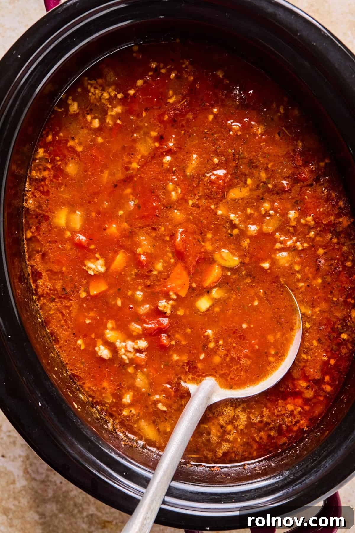 Slow Cooker Creamy Sausage Tortellini Soup 10 The crockpot filled with the Italian sausage and tomato-based soup, simmering and ready for the pasta and finishing touches.