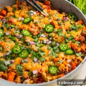 A hearty Ground Turkey Sweet Potato Skillet Dinner cooked in a single pan, with spoons ready to serve.