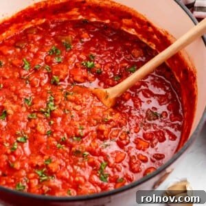 A pot of rich, cooked meat sauce made with ground turkey, generously topped with fresh parsley.