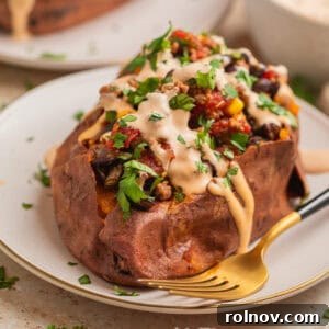 Delicious taco stuffed sweet potatoes with a drizzle of chipotle crema, garnished with fresh cilantro and lime wedges.