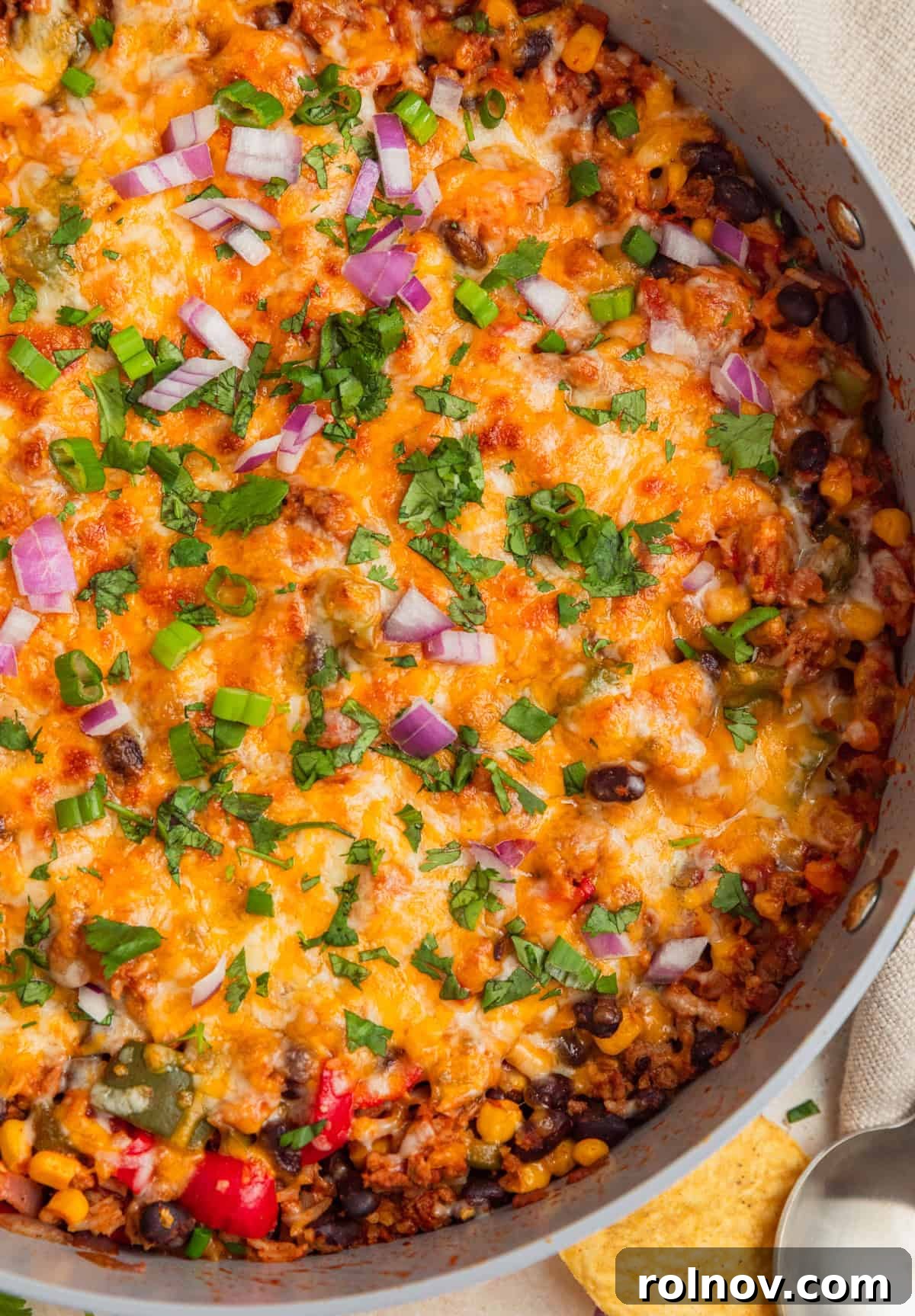 Skillet Turkey Taco Fiesta 2 Cheesy taco rice skillet topped with vibrant chopped cilantro, fresh green onions, and thinly sliced red onions, ready to serve.