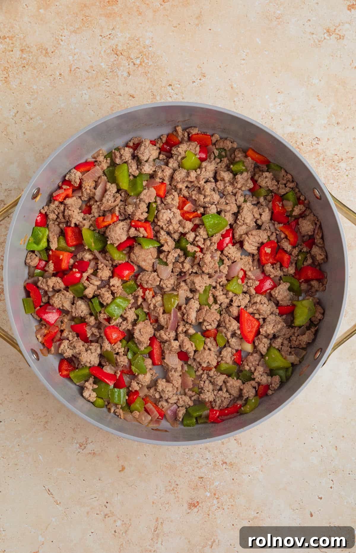 Skillet Turkey Taco Fiesta 6 Close-up of browned ground turkey mixed with softened onions and bell peppers in a large skillet.