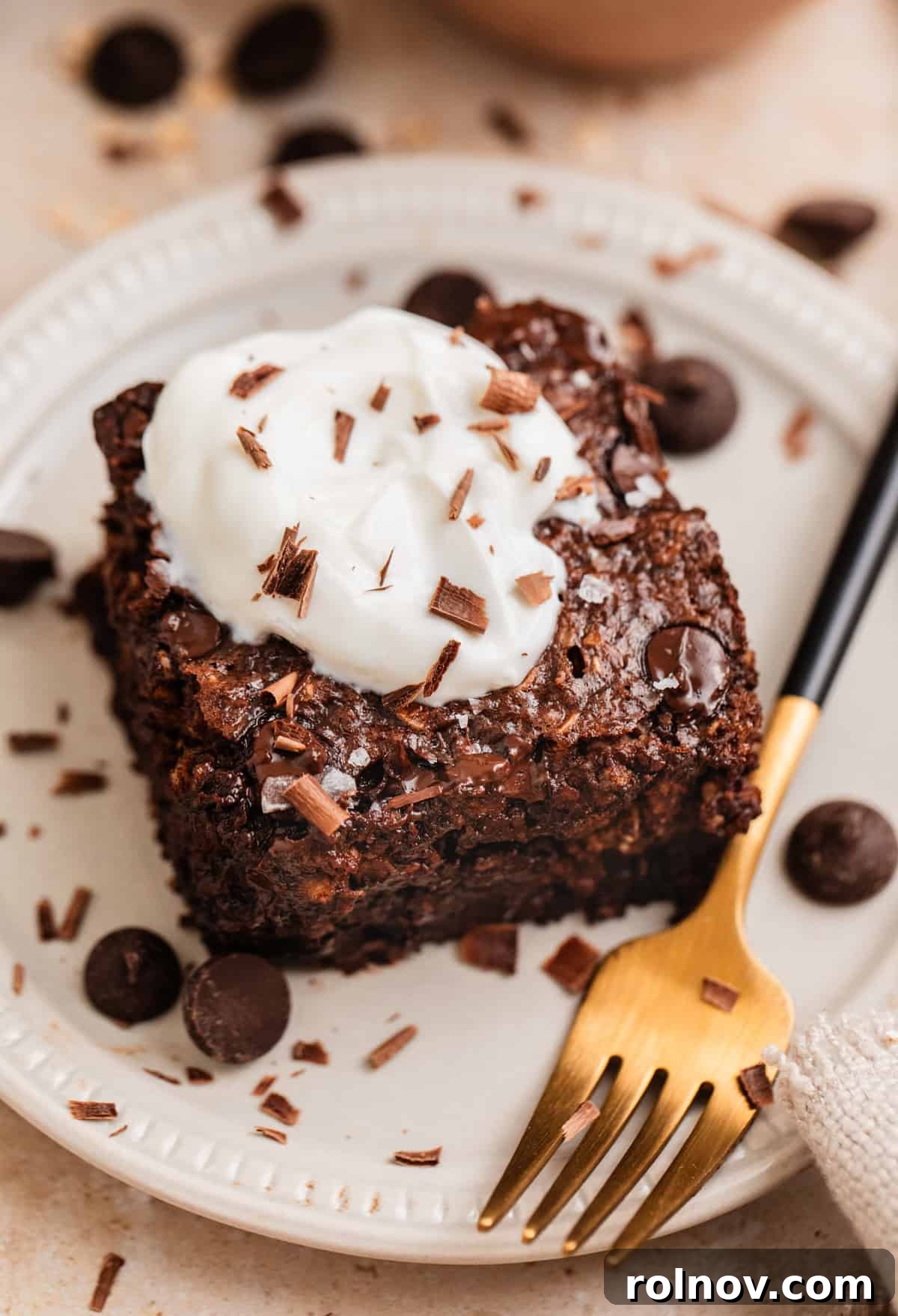 Decadent Chocolate Baked Oats 2 A perfectly sliced portion of rich chocolate baked oats, topped with a dollop of creamy Greek yogurt and a sprinkle of flaky sea salt, ready to be enjoyed as a delightful breakfast.