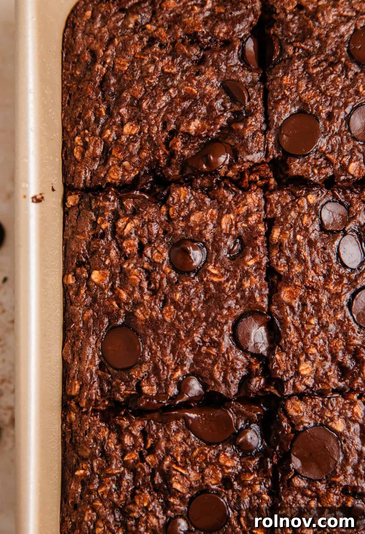 Decadent Chocolate Baked Oats 9 Chocolate baked oatmeal with chocolate chips visible, perfectly sliced and arranged within the baking pan.