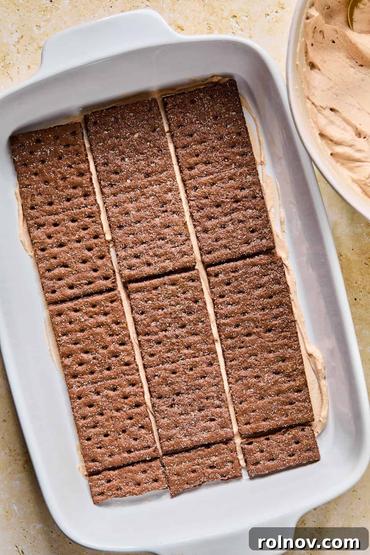 Decadent No-Bake Chocolate Cake 12 A single layer of chocolate graham crackers neatly arranged to cover the hot chocolate cream mixture at the bottom of the pan.