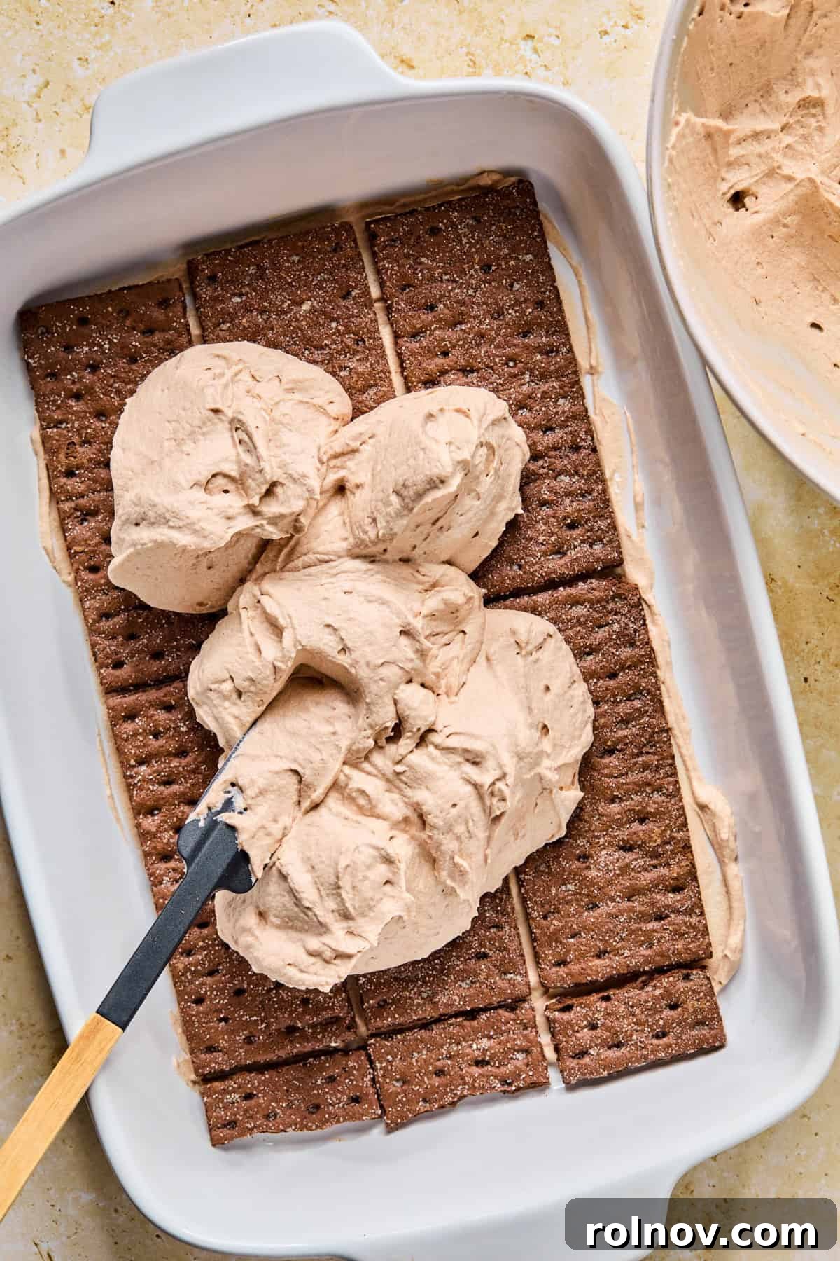 Decadent No-Bake Chocolate Cake 13 Dollops of chocolate cream mixture generously spread over the first layer of chocolate graham crackers in the pan.