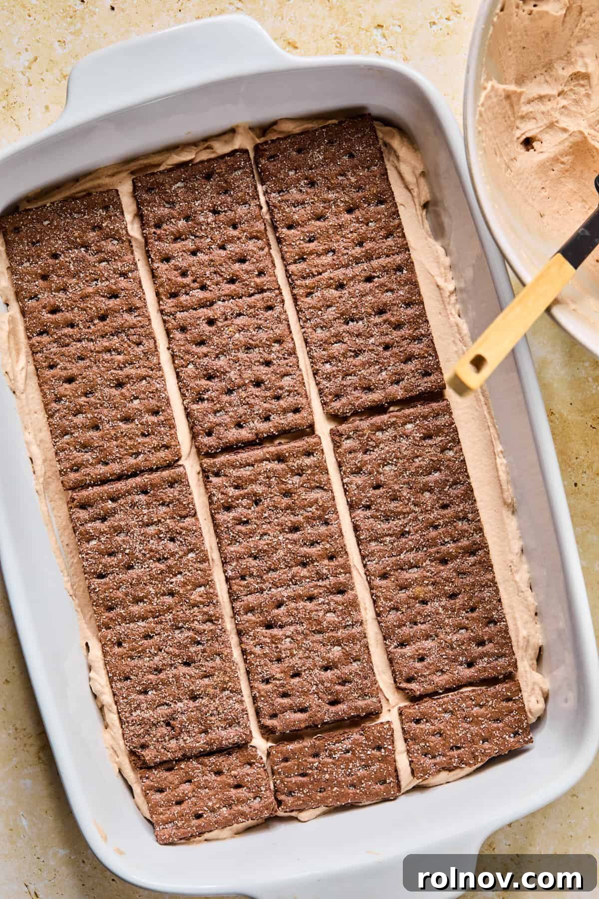 Decadent No-Bake Chocolate Cake 15 The final layer of chocolate graham crackers placed over the second layer of chocolate cream, ready for the top layer of cream.