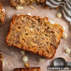 A perfectly baked slice of banana bread featuring visible white chocolate chips, surrounded by other inviting slices.
