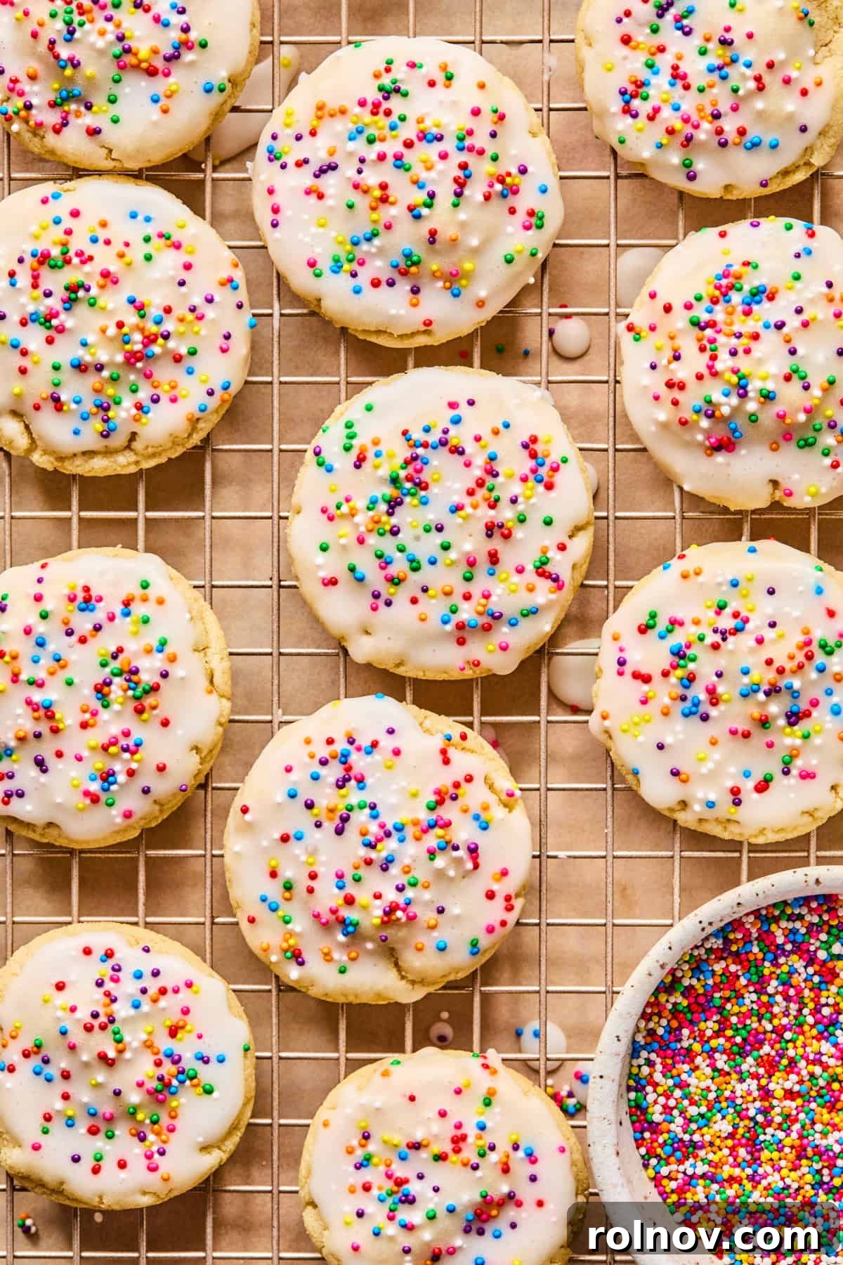 Frosted Sugar Delights 2 Delightfully chewy iced sugar cookies adorned with colorful nonpareils, cooling on a wire rack.