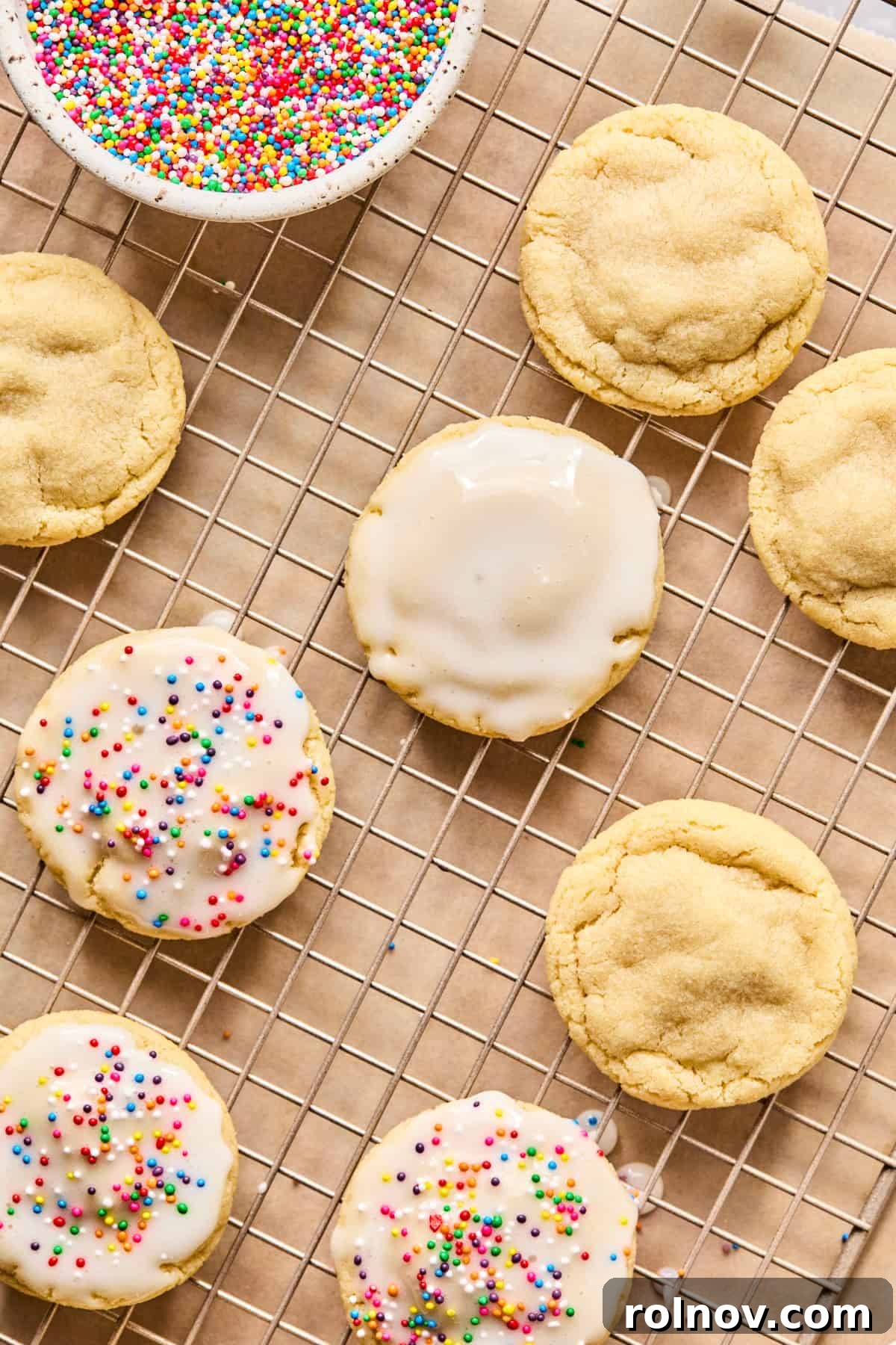 Frosted Sugar Delights 12 Iced sugar cookies adorned with nonpareils cooling on a wire rack.