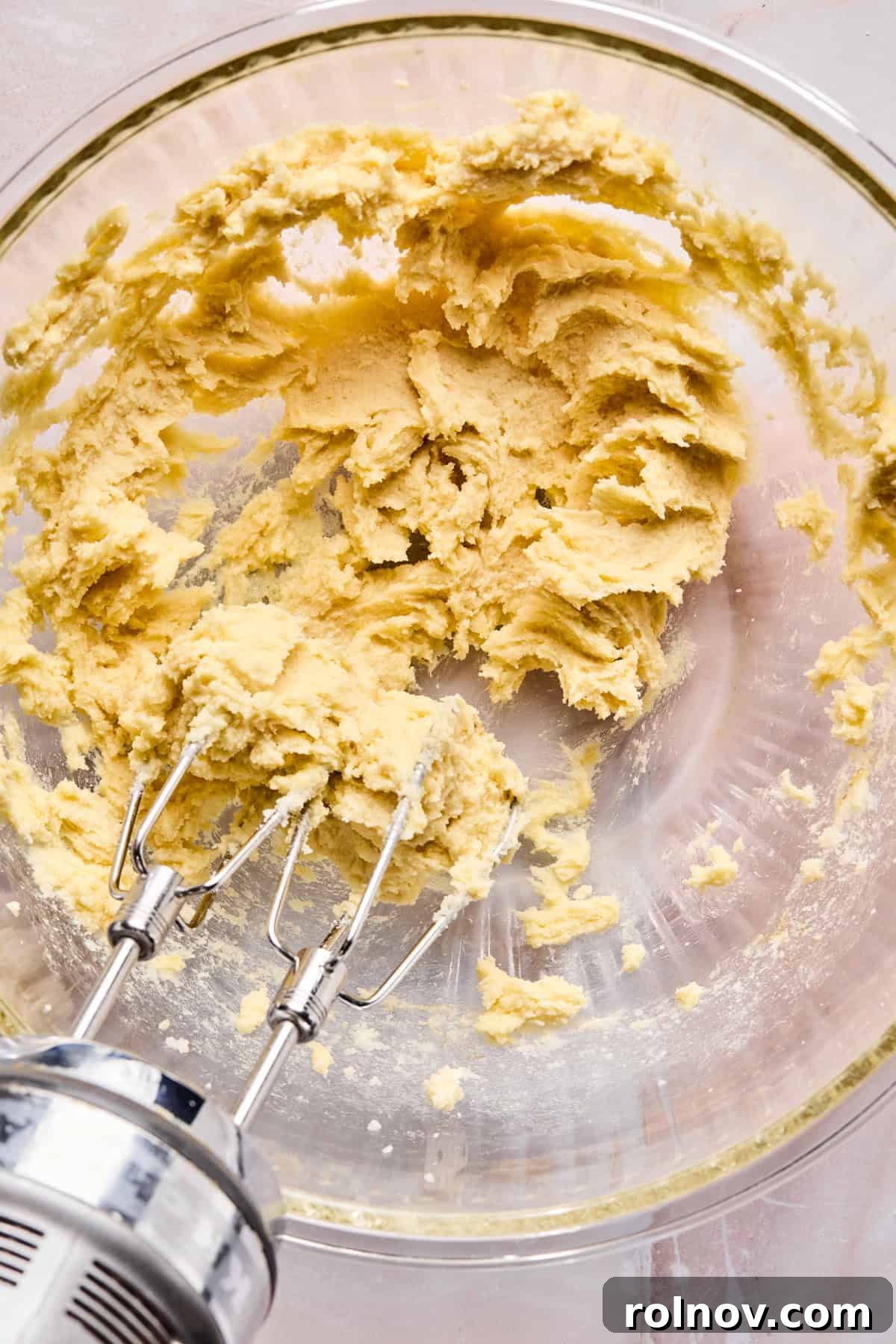 Frosted Sugar Delights 7 Egg yolk, vanilla, and almond extract being mixed into the creamed butter and sugar.