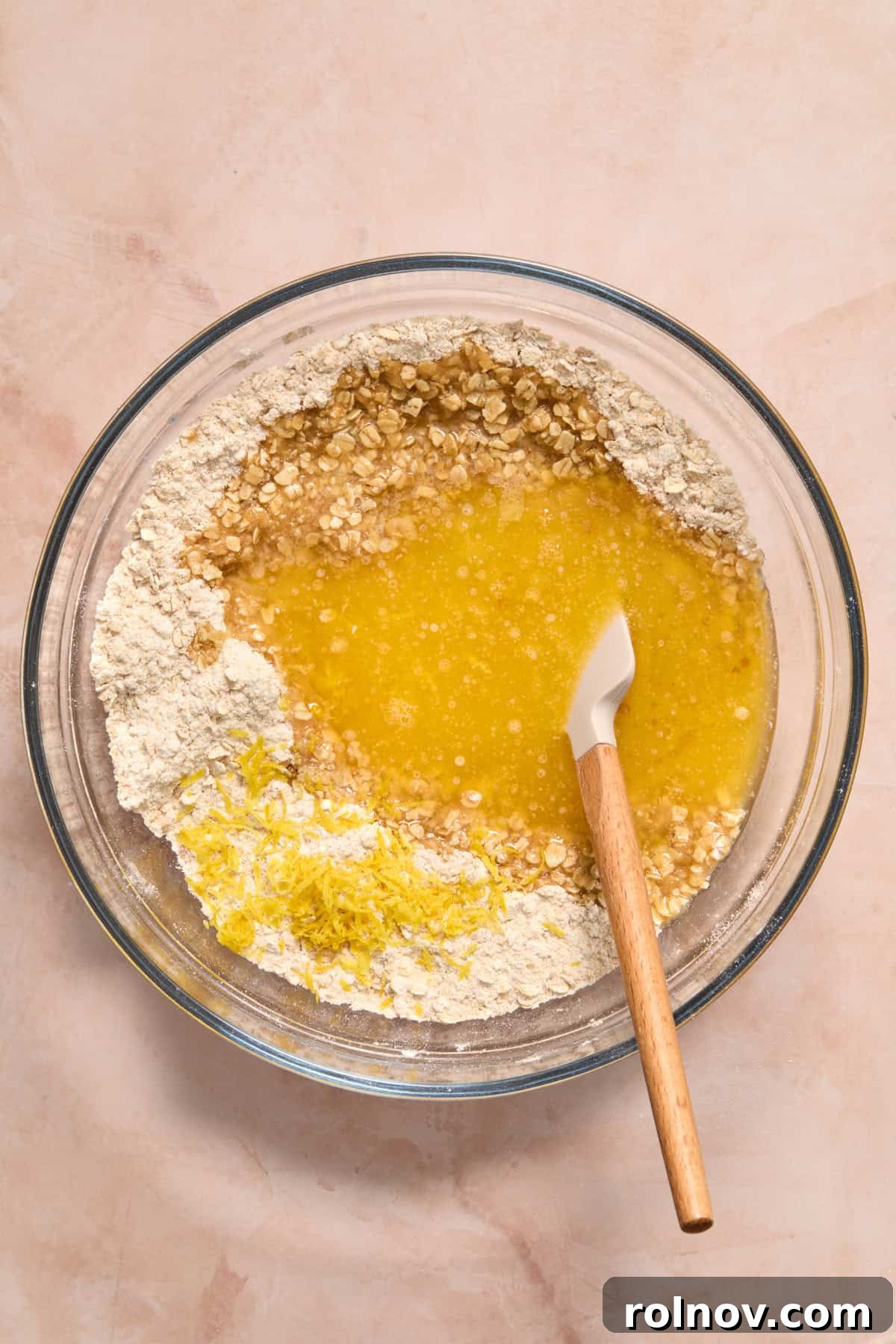 Bright Blueberry Lemon Squares 7 Melted butter, fresh lemon zest, and vanilla extract being added to the dry oat mixture in a bowl.
