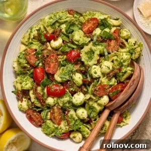 Bowl with prepared pesto tortellini salad topped with fresh chopped basil.