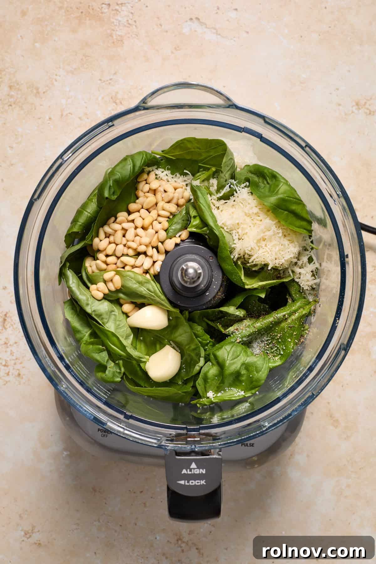 Basil, pine nuts, garlic and other ingredients added to food processor.
