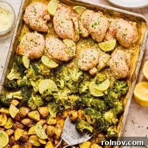 Lemon chicken sheet pan dinner on baking sheet with spatula.