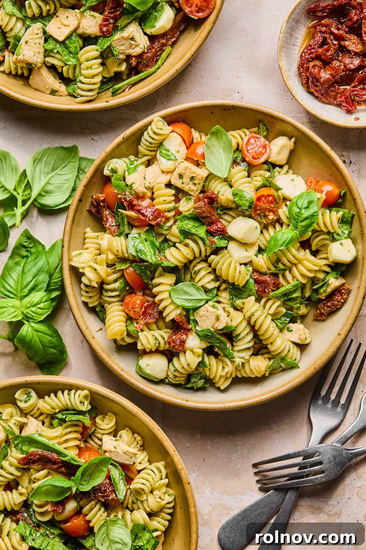 Creamy Pesto Chicken Pasta Salad Recipe for Summer Meals 11 Bowls with pesto pasta salad with chicken and forks.