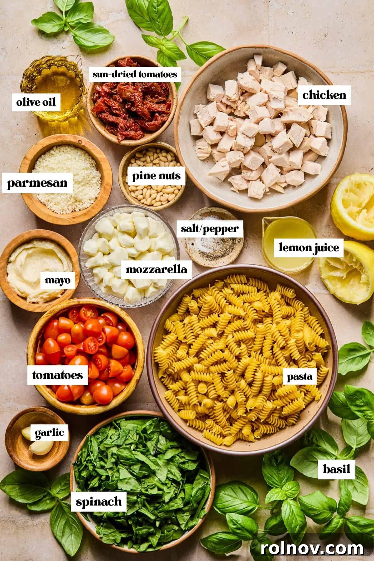Creamy Pesto Chicken Pasta Salad Recipe for Summer Meals 4 Spinach, basil, chicken, pasta and other ingredients for recipe labeled on surface.