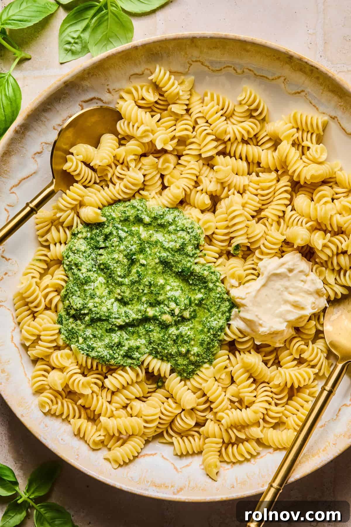 Creamy Pesto Chicken Pasta Salad Recipe for Summer Meals 7 Pesto and mayo over top of pasta in bowl with spoons.