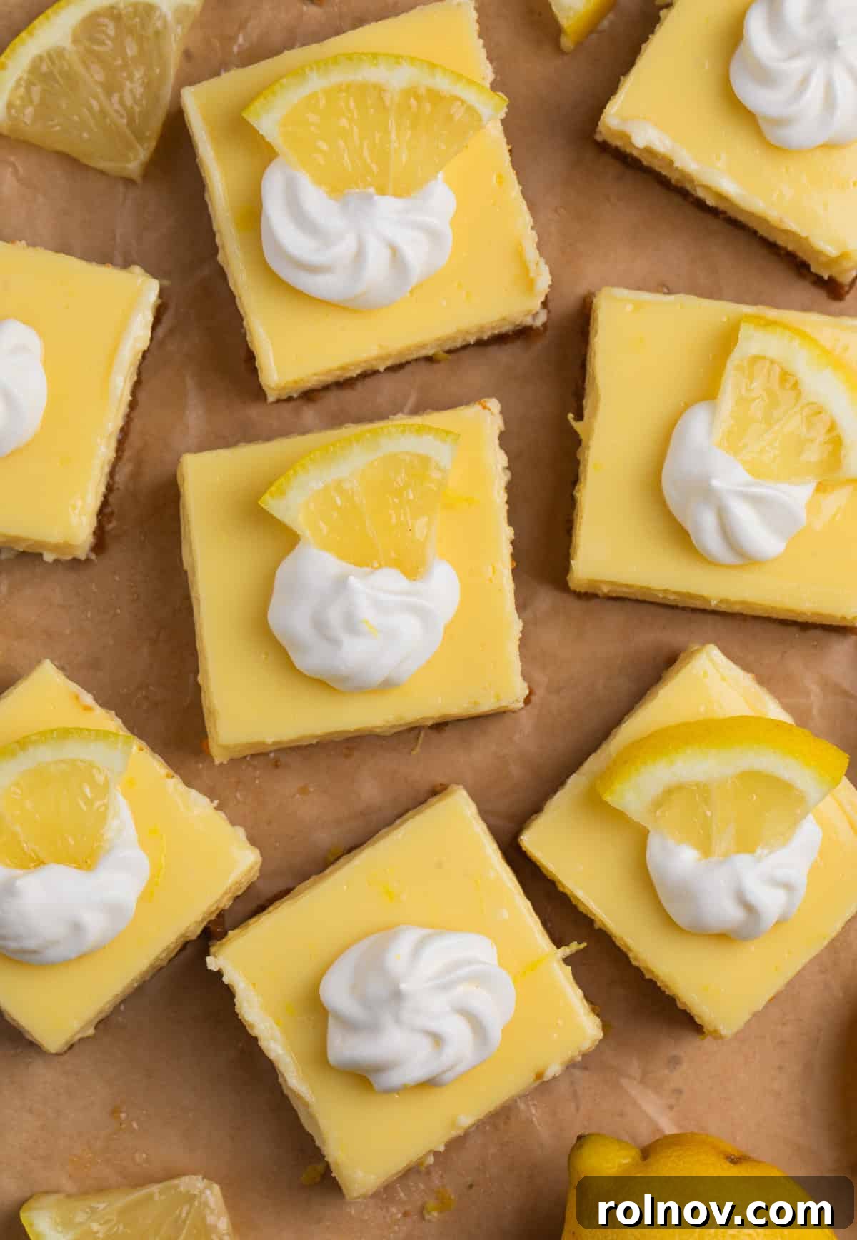 Creamy Lemon Bars with Graham Cracker Crust Recipe 13 Overhead view of lemon bars topped with whipped cream.