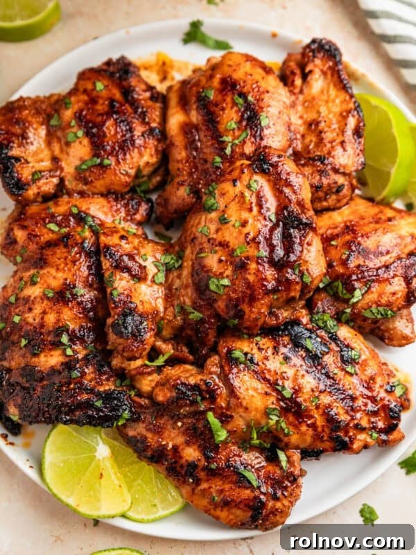 Sticky Honey Mustard Chicken Drumsticks Recipe 11 Overhead view of chili lime chicken on white plate with lime slices.