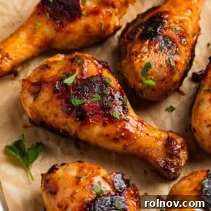 Sticky Honey Mustard Chicken Drumsticks Recipe 15 Honey mustard chicken drumsticks on parchment with chopped parsley.