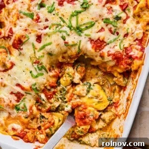Spinach and Ricotta Tortellini Bake Recipe for Weeknight Dinner 12 Casserole dish with baked cheesy tortellini with serving spoon scooping into it.