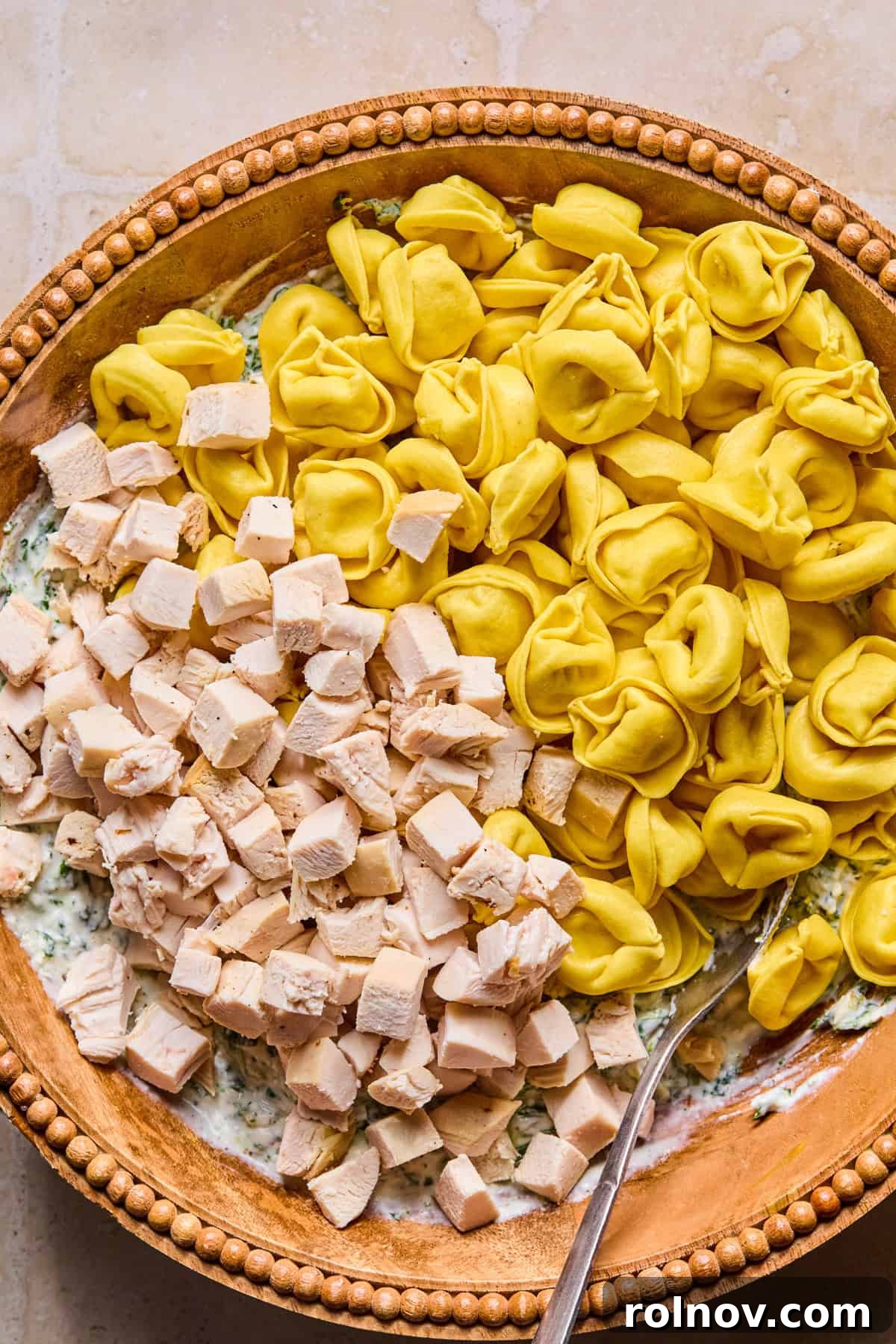 Spinach and Ricotta Tortellini Bake Recipe for Weeknight Dinner 7 Tortellini and cubed chicken in mixing bowl with cheese mixture.