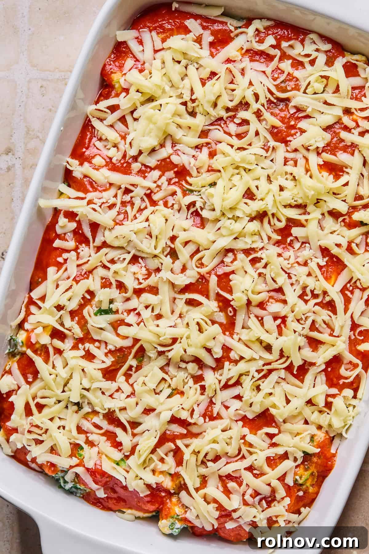 Spinach and Ricotta Tortellini Bake Recipe for Weeknight Dinner 9 Cheese covering marinara in pan with pasta.