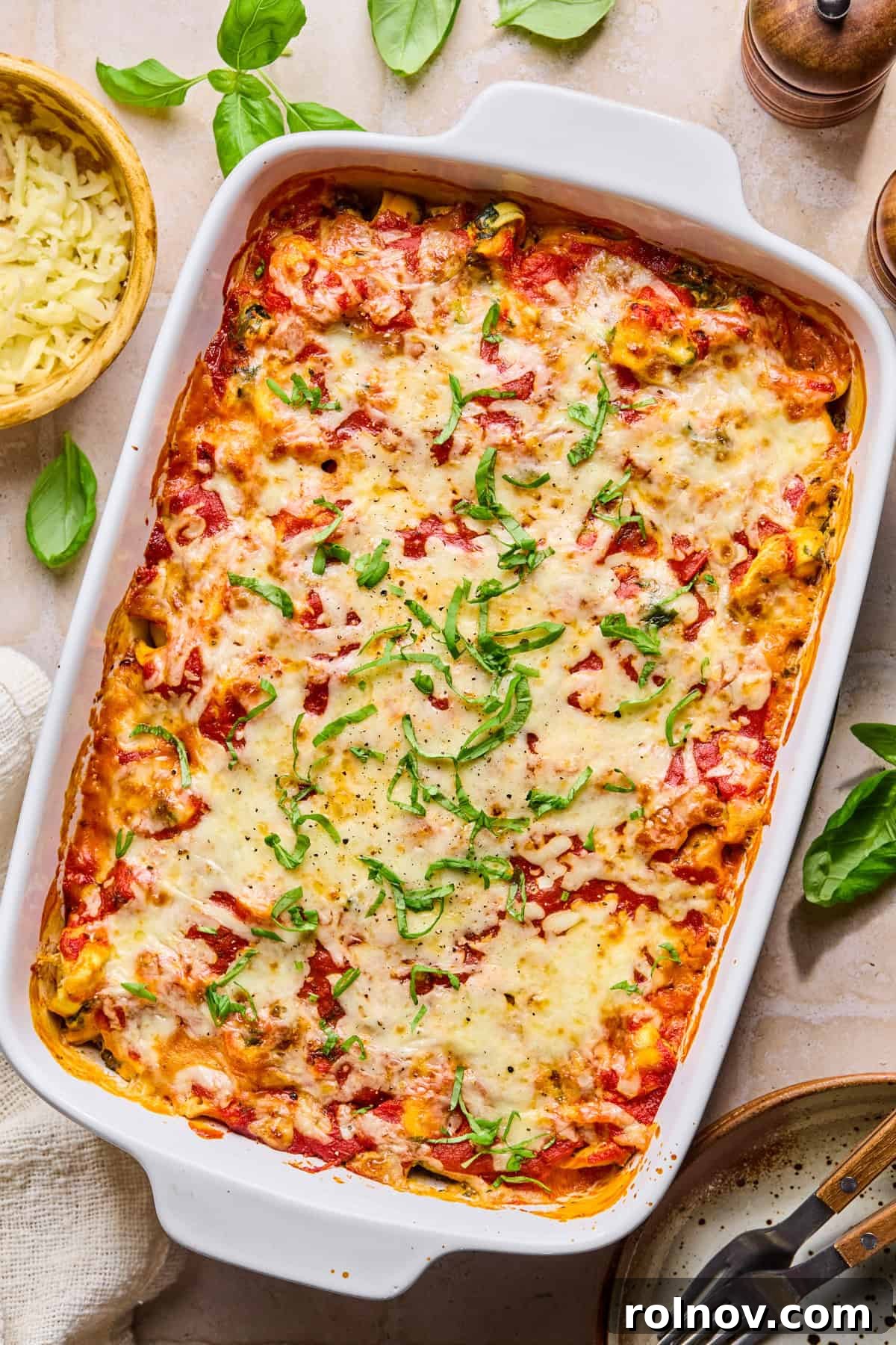 Spinach and Ricotta Tortellini Bake Recipe for Weeknight Dinner 10 Spinach and ricotta cheesy tortellini baked pasta with chopped basil on top.