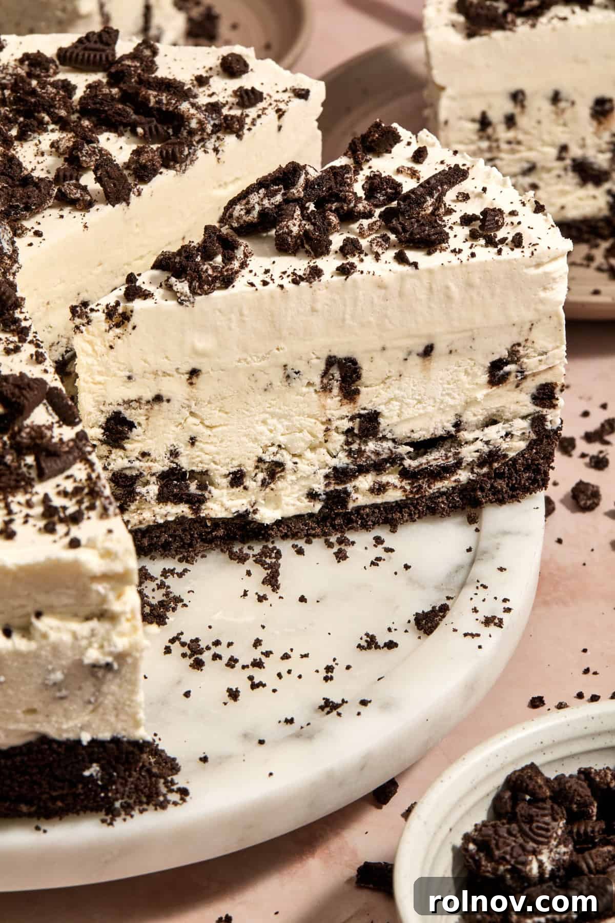 Oreo Ice Cream Pie Recipe: No-Bake Cookies and Cream Dessert 13 Ice cream pie on cake plate with whipped cream layer and crushed chocolate cookies on top.