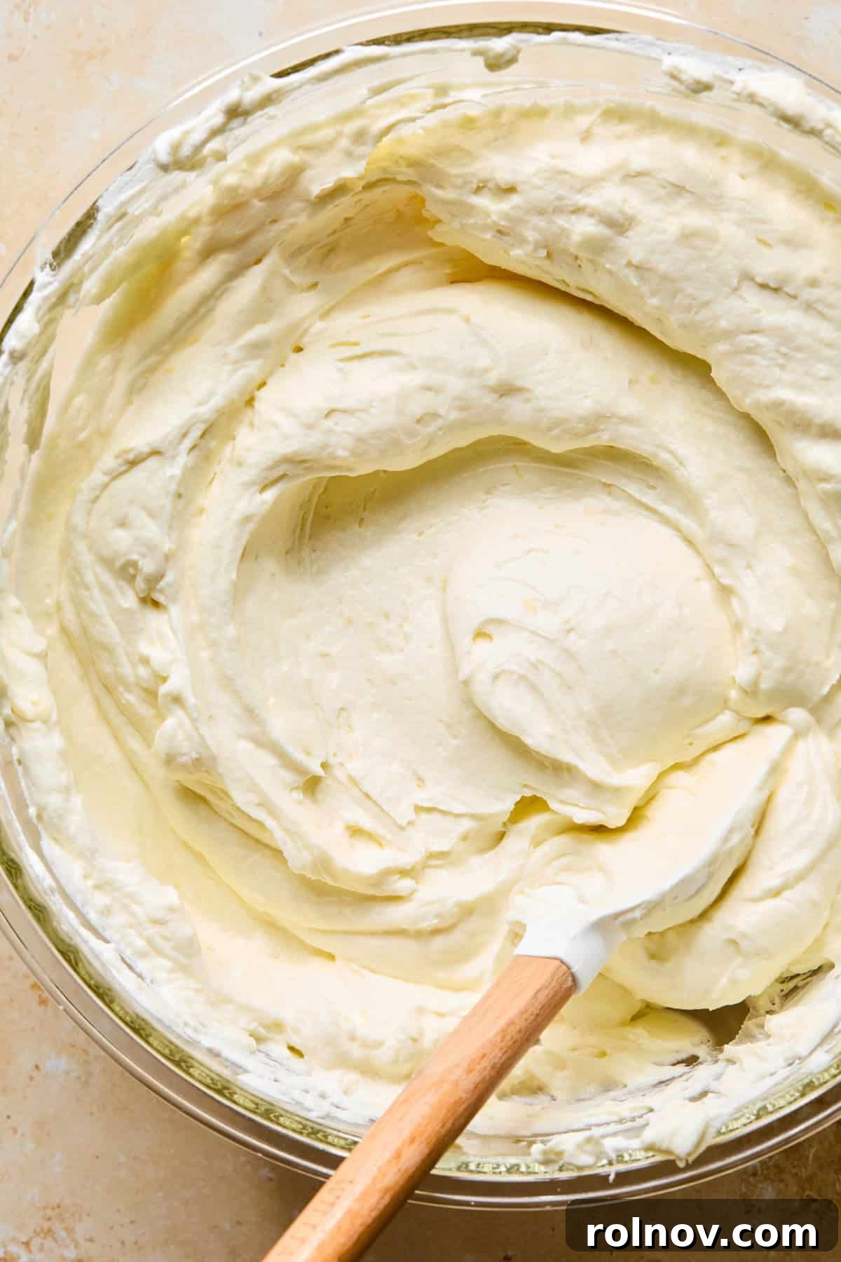 No-Bake Lemon Cheesecake Bars Recipe — Creamy Citrus Dessert 13 No-bake lemon cheesecake mixture with spatula in bowl.