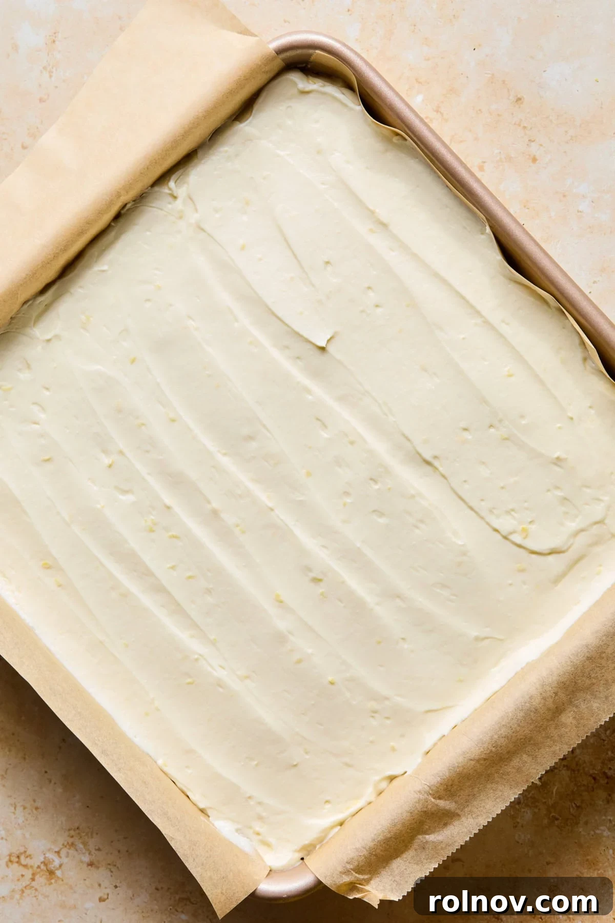 No-Bake Lemon Cheesecake Bars Recipe — Creamy Citrus Dessert 14 No-bake lemon cheesecake in pan spread evenly.