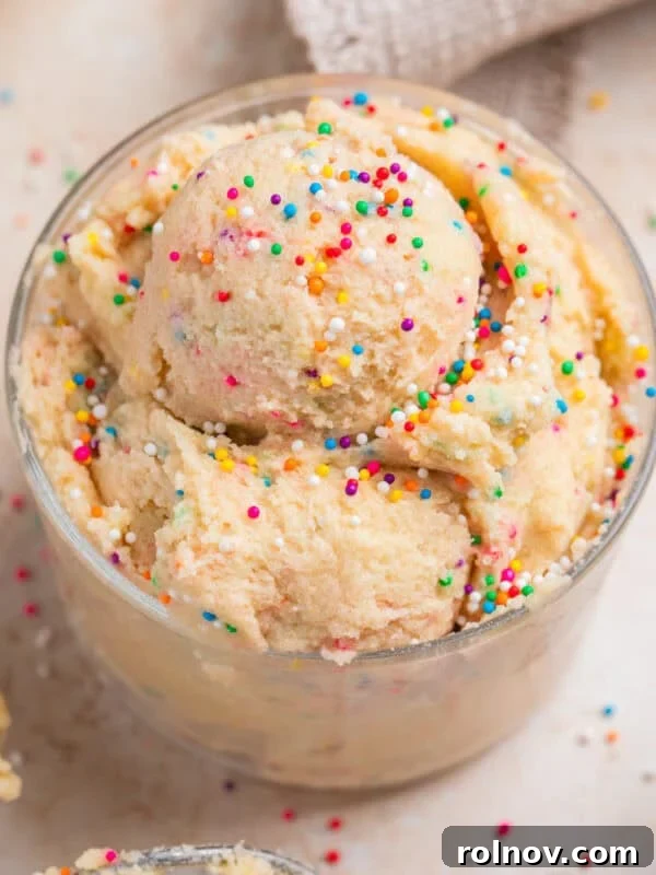 No-Bake Lemon Cheesecake Bars Recipe — Creamy Citrus Dessert 19 Edible sugar cookie dough with sprinkles in cup topped with more sprinkles.