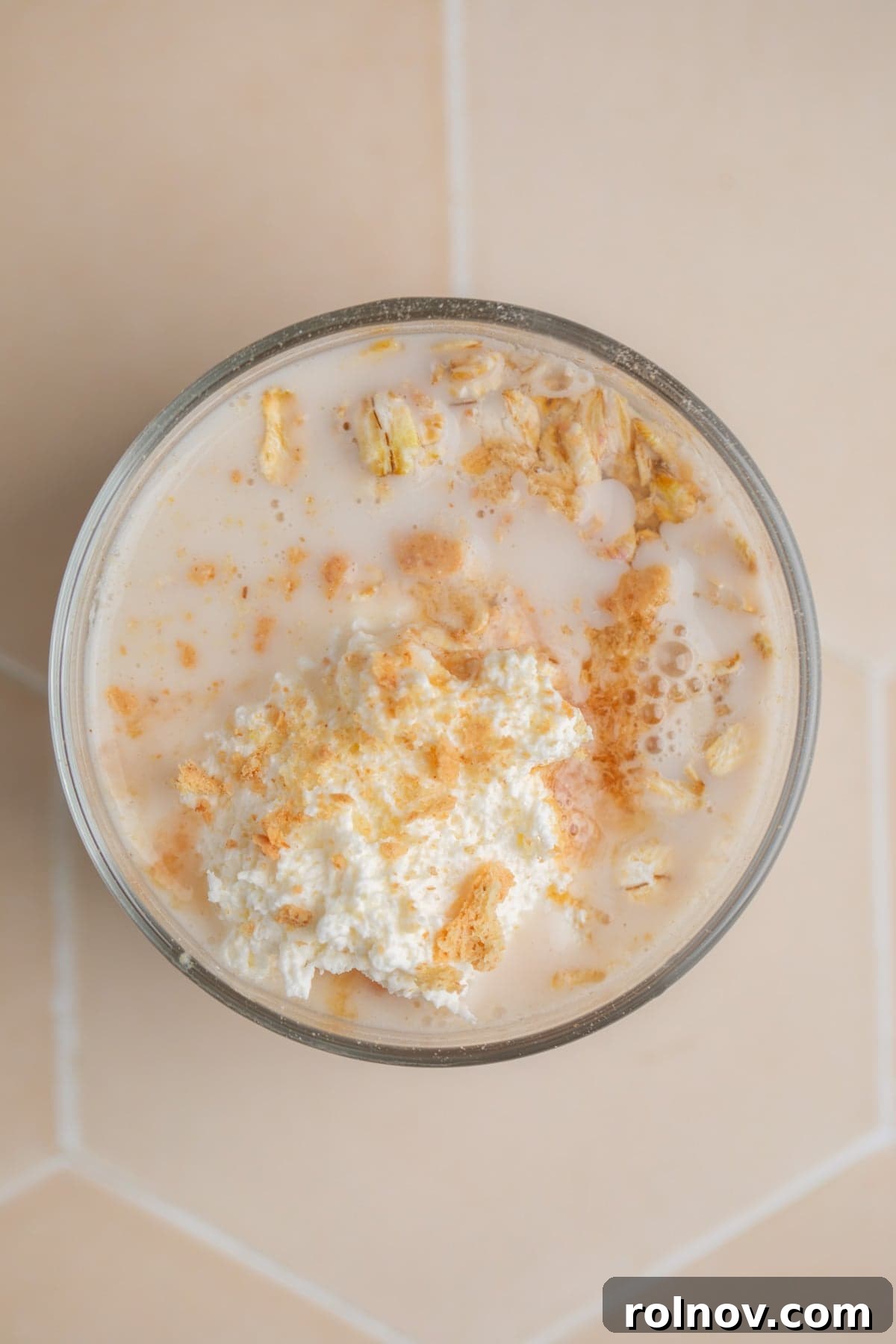 Overnight oatmeal mixture in glass jar before mixing.