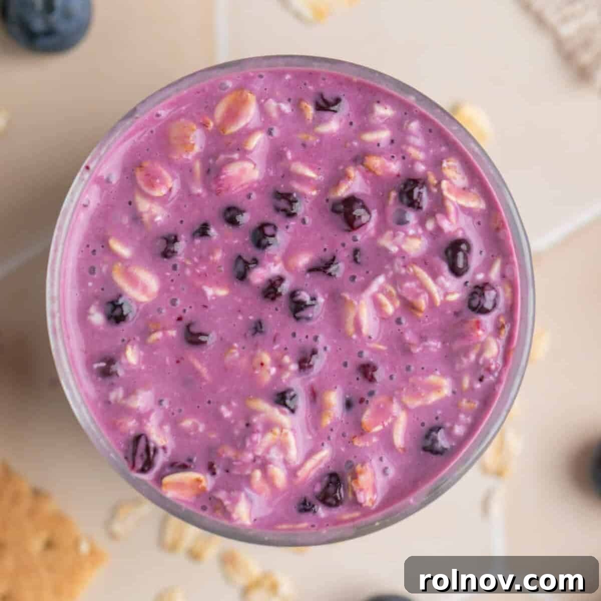 Prepared overnight oatmeal with blueberries and cream cheese in glass cup.